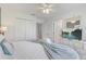 Bedroom with a white bed, ceiling fan, and TV, with a light blue throw blanket at 1041 Park Ridge Cir, Kissimmee, FL 34746
