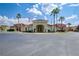 Inviting clubhouse entrance with well-maintained landscaping, palm trees, and American flags, offering a welcoming atmosphere at 1041 Park Ridge Cir, Kissimmee, FL 34746