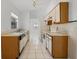 Galley kitchen featuring white appliances, wood cabinets, and updated lighting at 11113 Sylvan Pond Cir, Orlando, FL 32825