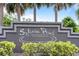 Community entrance sign for Sylvan Pond beneath palm trees and blue skies at 11113 Sylvan Pond Cir, Orlando, FL 32825
