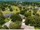 Aerial view showcasing surrounding community, lush greenery, mature trees, and a nearby tennis court at 11335 Winston Willow Ct, Windermere, FL 34786