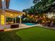 Twilight view of a backyard with a pool, putting green, patio area, and ambient string lights, great for entertaining at 11335 Winston Willow Ct, Windermere, FL 34786