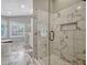 Modern bathroom with a marble shower, a soaking tub, a double vanity and lots of natural light at 11335 Winston Willow Ct, Windermere, FL 34786