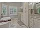 Bright bathroom with marble floors, a soaking tub, white cabinets, and a double vanity at 11335 Winston Willow Ct, Windermere, FL 34786