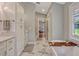 Bright bathroom with marble floors, a soaking tub, white cabinets, a double vanity and ample storage at 11335 Winston Willow Ct, Windermere, FL 34786