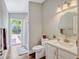 Well-lit bathroom with a modern vanity, toilet, and shower, seamlessly connecting to the outdoors at 11335 Winston Willow Ct, Windermere, FL 34786