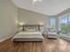 Large bedroom featuring a comfortable bed, accent chair, natural light and views of the backyard at 11335 Winston Willow Ct, Windermere, FL 34786