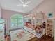 Pink bedroom with bunk beds, playful decor, and ample natural light from a large window at 11335 Winston Willow Ct, Windermere, FL 34786