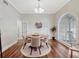Bright dining room with wood floors, a round table, and a large arched window that floods the room with natural light at 11335 Winston Willow Ct, Windermere, FL 34786