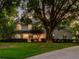Two-story home surrounded by mature trees and inviting warm lights at 11335 Winston Willow Ct, Windermere, FL 34786