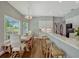 Sunlit kitchen with white cabinets, hardwood floors, bar stool seating, and adjacent dining area with backyard views at 11335 Winston Willow Ct, Windermere, FL 34786