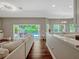 Open-concept living room featuring a kitchen island, hardwood floors, and sliding glass doors to the pool at 11335 Winston Willow Ct, Windermere, FL 34786