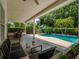 Inviting pool area with covered patio, surrounded by well-maintained landscaping for outdoor enjoyment at 11335 Winston Willow Ct, Windermere, FL 34786