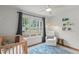 Bright Bedroom featuring a crib, plush chair, and colorful bookshelf at 1207 W New Hampshire St, Orlando, FL 32804