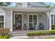 Front porch with dark wood door, decorative plants, comfortable seating, and manicured landscaping at 1207 W New Hampshire St, Orlando, FL 32804