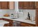 Elegant kitchen sink with marble countertops, stainless steel faucet, and classic wood cabinets at 1207 W New Hampshire St, Orlando, FL 32804