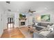Bright living room with a decorative fireplace, hardwood floors, gray sectional, and modern ceiling fan at 1207 W New Hampshire St, Orlando, FL 32804