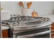 Close-up of a stainless steel gas cooktop with white tile backsplash and wood cabinets at 1207 W New Hampshire St, Orlando, FL 32804