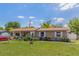 Charming single-story home featuring a lush lawn, lovely garden beds, and an American flag at 1219 Blue Spring Ct, Ocoee, FL 34761