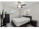 Modern bedroom with two windows, wood-look floors, and a dark finish bed frame and furniture at 13 Fanfair Ave, Orlando, FL 32811