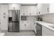 Modern kitchen featuring stainless steel appliances, white cabinets, and elegant countertops at 13 Fanfair Ave, Orlando, FL 32811