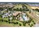 Aerial view of the community clubhouse, pool, and landscaping, with the golf course in the background at 1300 Island Green St, Davenport, FL 33896
