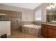 Well-lit bathroom with soaking tub, tiled shower, and granite vanity at 1300 Island Green St, Davenport, FL 33896