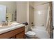 Clean bathroom featuring a shower-tub combo with a floral shower curtain and ample vanity space at 1300 Island Green St, Davenport, FL 33896