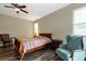 Cozy bedroom with a ceiling fan, wood-look floors, and a comfortable chair at 1300 Island Green St, Davenport, FL 33896
