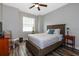Comfortable bedroom with a ceiling fan, wood-look flooring, and natural light at 1300 Island Green St, Davenport, FL 33896