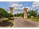Entrance to the community featuring an ornate gate and lush landscaping for a welcoming arrival at 1300 Island Green St, Davenport, FL 33896