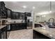 Modern kitchen with granite countertops, stainless steel appliances, and dark cabinetry at 1300 Island Green St, Davenport, FL 33896