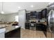 Modern kitchen with dark cabinets, stainless steel appliances and granite countertops at 1300 Island Green St, Davenport, FL 33896