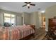 Comfortable main bedroom with wood-look floors, ceiling fan, and en-suite bathroom at 1300 Island Green St, Davenport, FL 33896