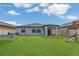 The backyard features green grass, a patio, playset, and trampoline near a single-story home at 1312 Axel Graeson Ave, Kissimmee, FL 34744