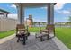 Outdoor patio area with stylish seating, fire pit, and views of the green backyard with playset and lake at 1312 Axel Graeson Ave, Kissimmee, FL 34744
