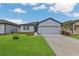 Charming one-story home featuring a well-manicured lawn and a two-car garage at 1312 Axel Graeson Ave, Kissimmee, FL 34744