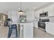 Modern kitchen with white cabinets, stainless appliances, and an island with bar seating at 1312 Axel Graeson Ave, Kissimmee, FL 34744