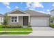 Charming single-story home featuring a two-car garage, manicured lawn, and inviting front entrance with stone accents at 13248 Pergola Ave, Orlando, FL 32832