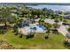 Aerial view of a community pool with surrounding green spaces and a lake in the distance at 13299 Serene Valley Dr, Clermont, FL 34711