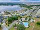 Aerial view of a neighborhood with a lake, a community pool, and residential houses at 13299 Serene Valley Dr, Clermont, FL 34711