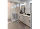 Stylish bathroom with white cabinets, double sinks, and tiled walk-in shower at 13299 Serene Valley Dr, Clermont, FL 34711