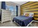 Cozy bedroom featuring a large window, a comfortable bed, and cheerful space-themed decor at 13299 Serene Valley Dr, Clermont, FL 34711