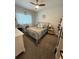 Cozy bedroom featuring plush carpet, ceiling fan, and a large window with natural light at 13299 Serene Valley Dr, Clermont, FL 34711
