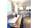 Bright dining room with wood table, gray chairs, modern lighting and views into the kitchen at 13299 Serene Valley Dr, Clermont, FL 34711