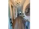 Bright and inviting foyer with hardwood floors, decorative mirror, and statement lighting fixture at 13299 Serene Valley Dr, Clermont, FL 34711
