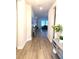 Hallway features wood-look floors, neutral paint, and leads to a view of the living room at 13299 Serene Valley Dr, Clermont, FL 34711