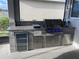 Outdoor kitchen featuring a grill, beverage cooler, granite countertop, and cabinet storage at 13299 Serene Valley Dr, Clermont, FL 34711