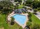 Aerial view of a community pool with a bath house, surrounded by lush landscaping and lounge chairs at 13299 Serene Valley Dr, Clermont, FL 34711