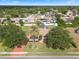 Aerial view of home with mature trees, screened-in lanai, and long decorative driveway at 1441 Olde Kensington Ln, Deltona, FL 32725
